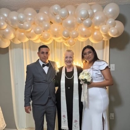 Sarah with a couple beneath a balloon garland