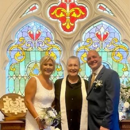 Sarah with a couple in a church sanctuary