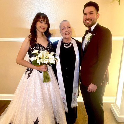 Sarah with a couple in an elegant ballroom